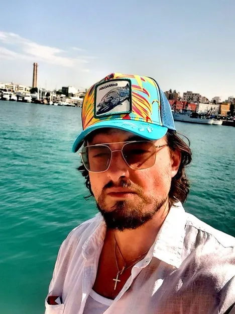 Kamil Rudawski w czapce i okularach, nad wodą