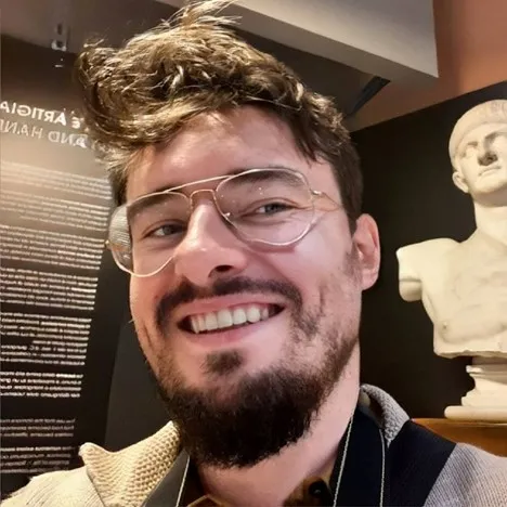 Kamil Rudawski uśmiechnięty w okularach